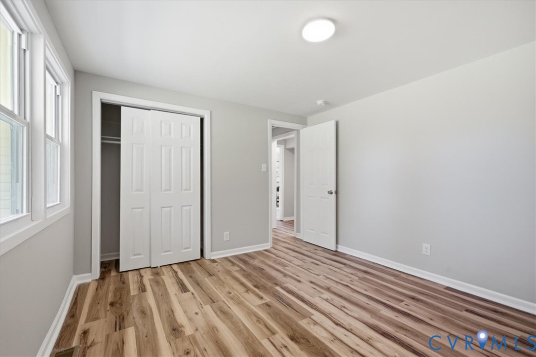 Wood-finish flooring, white trim, recessed lighting, and a bi-fold closet
