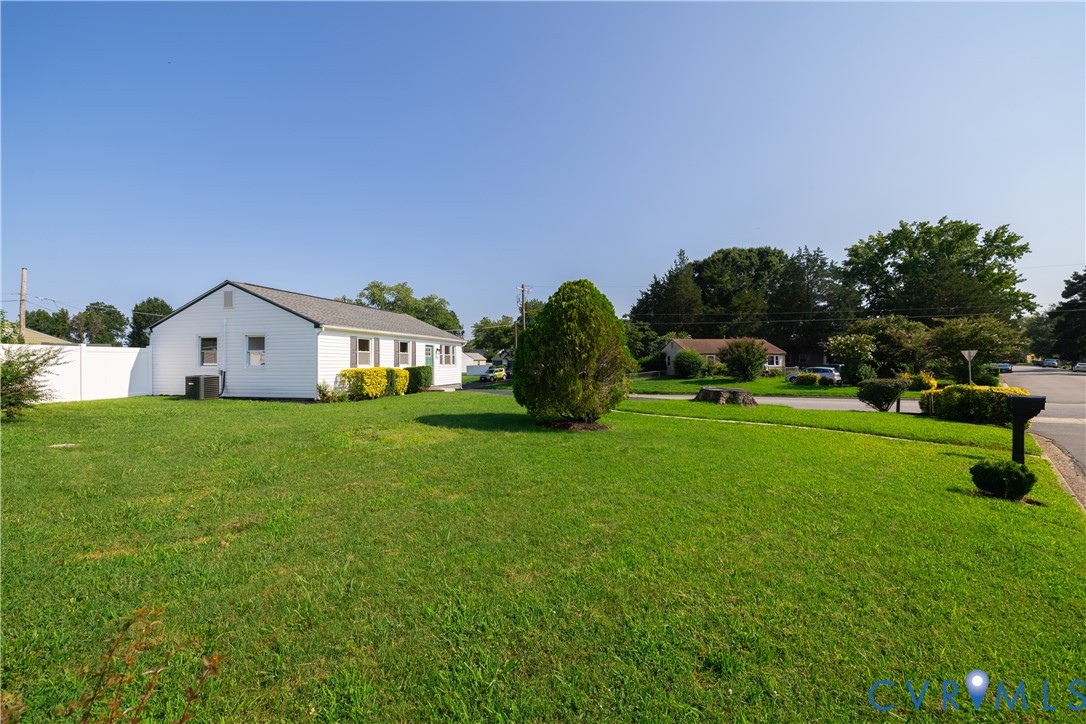 Expansive green lawn, white vinyl fencing, and mature landscaping