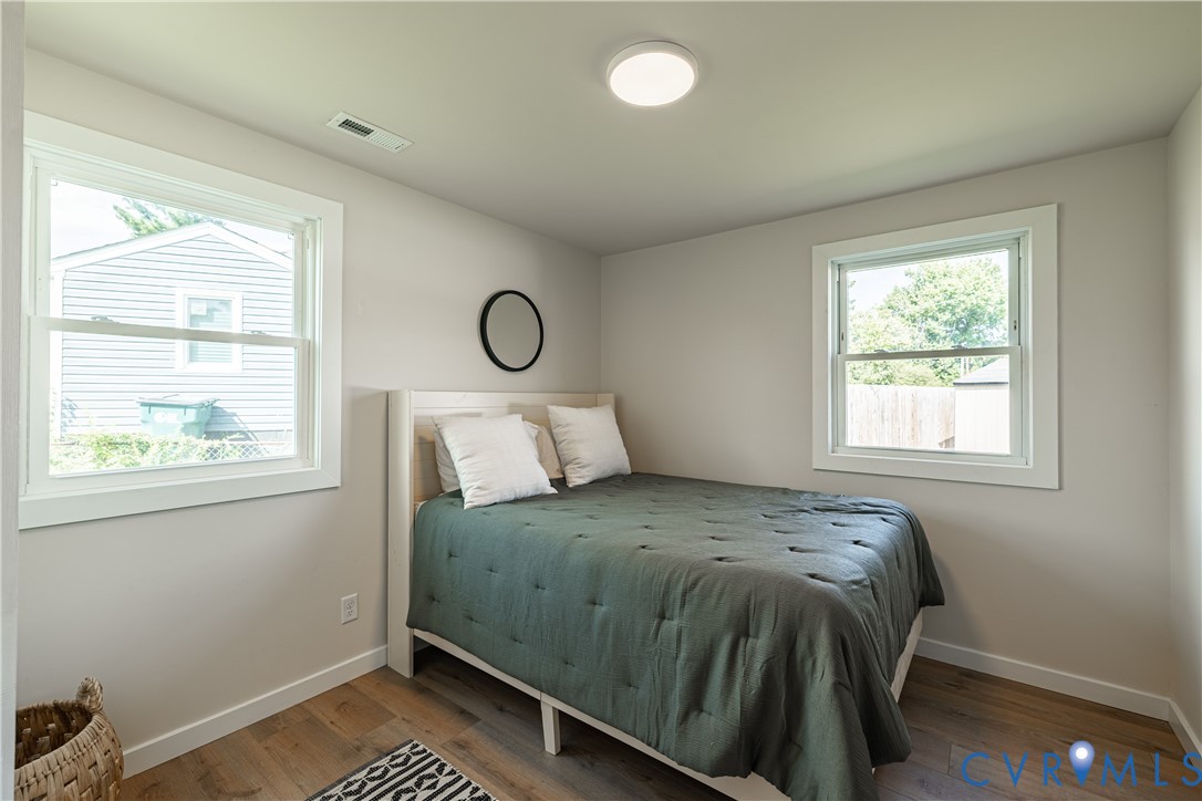 Light-toned walls, wood-finish flooring, two windows, and a ceiling-mounted flush light fixture