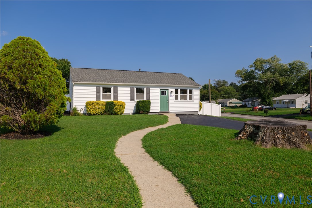White siding exterior with gray shutters, asphalt shingle roof, paved driveway, and a concrete pathway