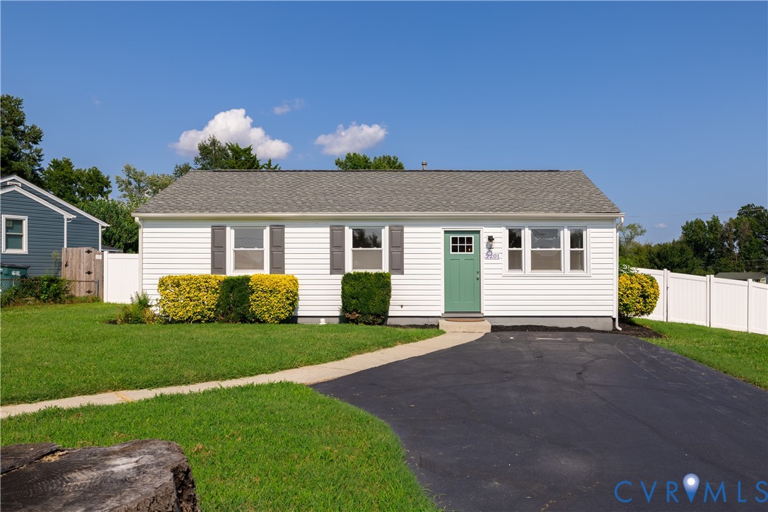 White vinyl siding exterior with a green entry door