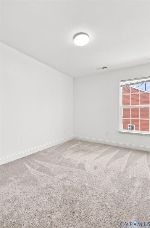 Recessed lighting, light-toned carpeting, and white wall finishes