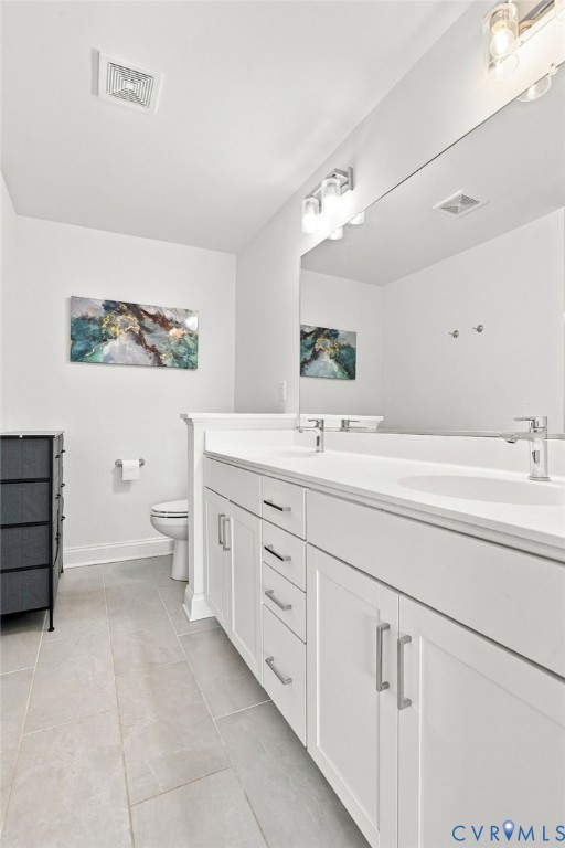Dual vanity featuring white cabinetry, integrated sinks, chrome hardware, and a large wall-mounted mirror
