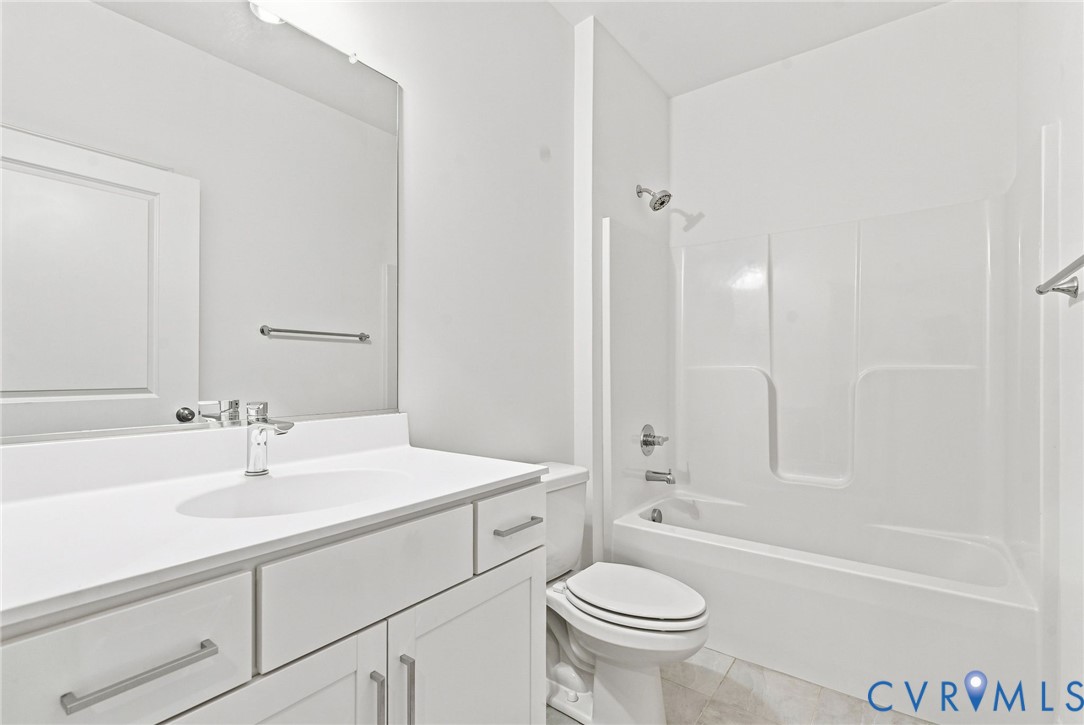 White vanity with integrated sink, chrome faucet, and rectangular mirror