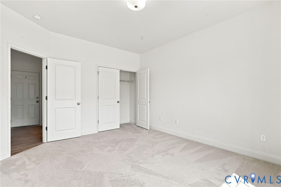 Recessed lighting, light-toned carpeting, white interior doors, and a built-in closet