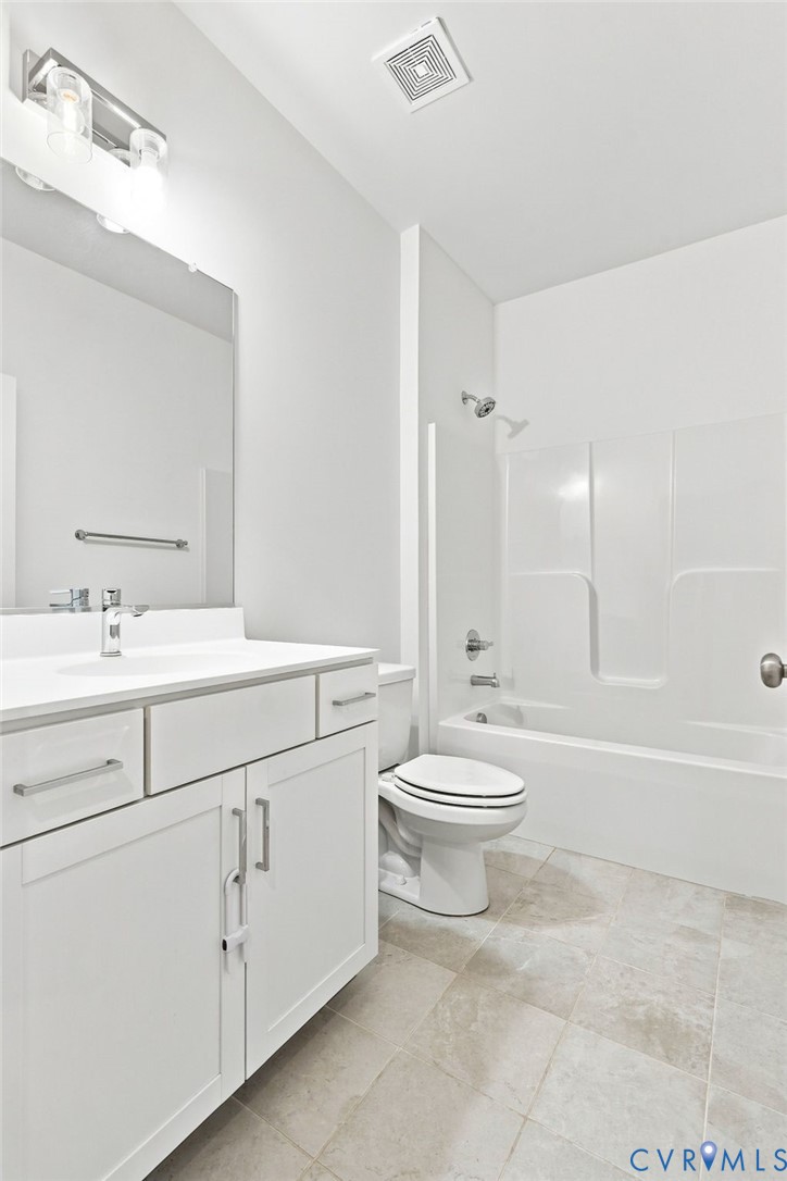 White vanity with a solid surface countertop, undermount sink, and brushed nickel fixtures