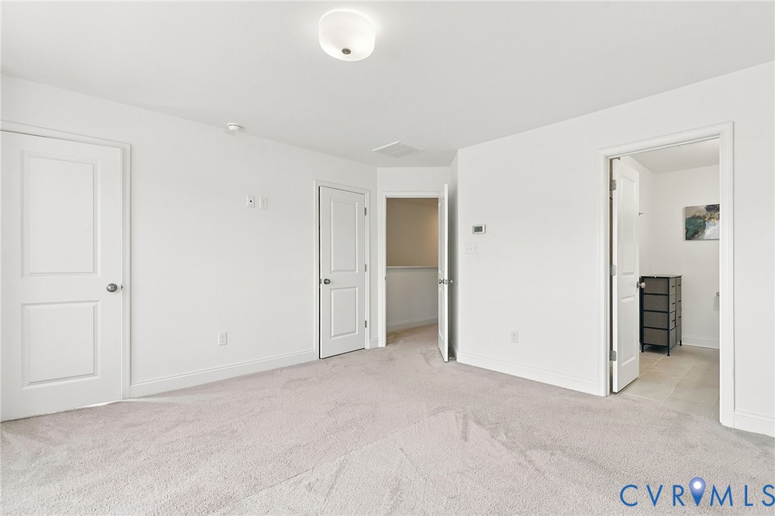 Neutral color palette with light-toned carpeting and flush-mount ceiling light