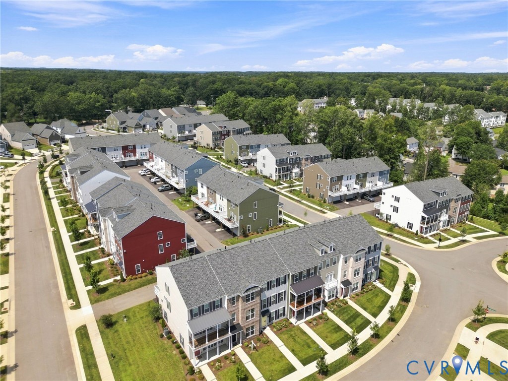 Community featuring townhome-style residences with covered balconies, individual parking spaces, and manicured landscaping