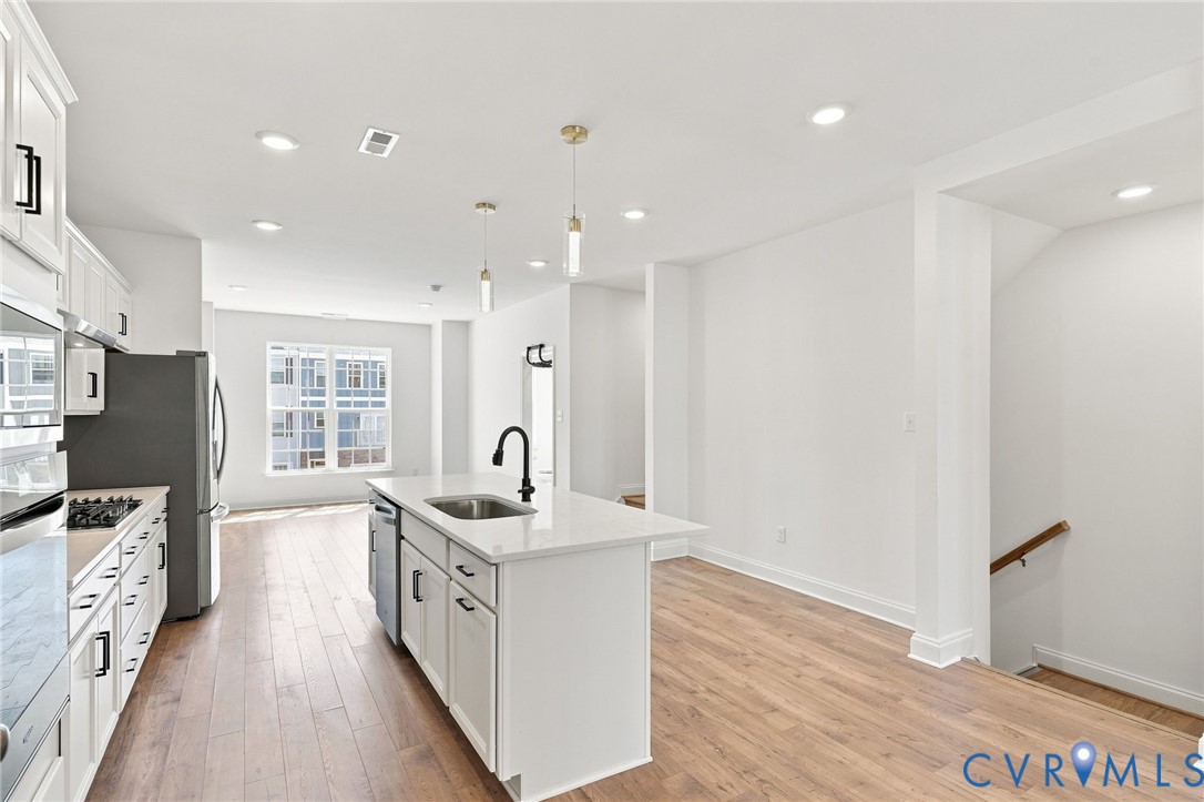 Open-concept living area featuring wood-finish flooring and recessed lighting