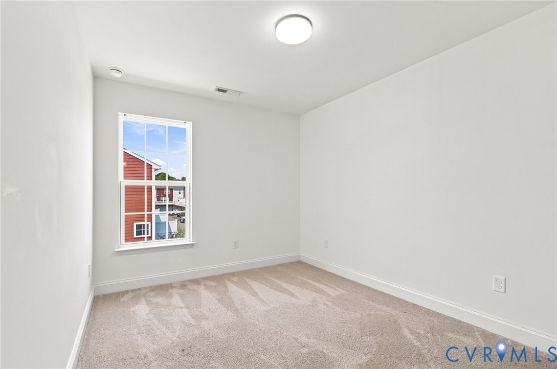 Neutral tone wall finishes, light-toned carpeting, and a double-hung window