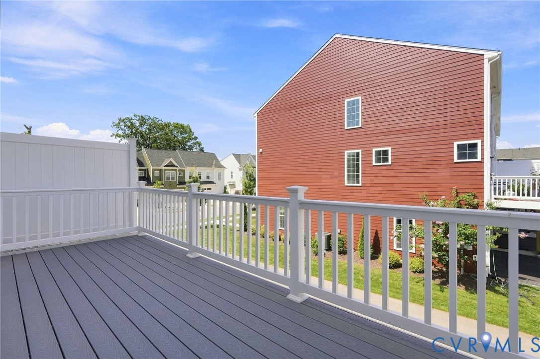 Deck with composite flooring, white railing, and white privacy fencing