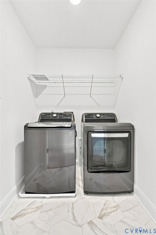 Integrated laundry appliances with a wire shelving unit, overhead lighting, and hexagonal tile flooring