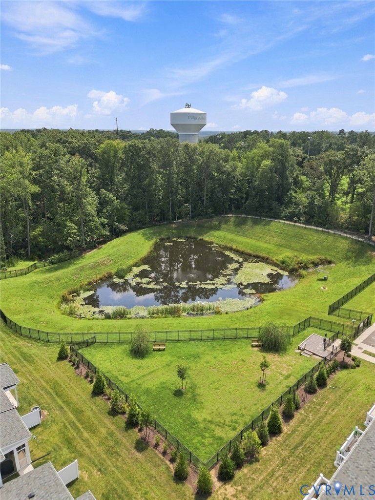 Expansive green space featuring a pond and fenced areas