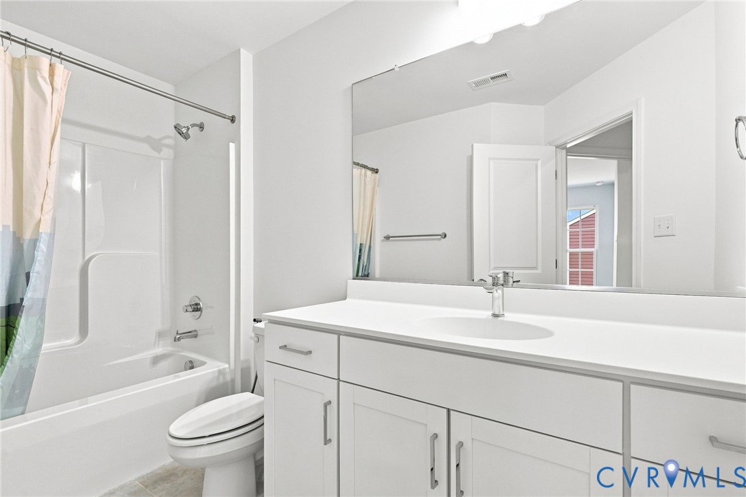 White vanity with integrated sink, chrome faucet, and expansive wall-mounted mirror