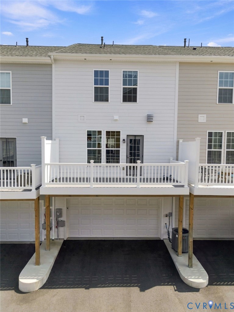 White vinyl siding exterior with an elevated deck featuring white railings