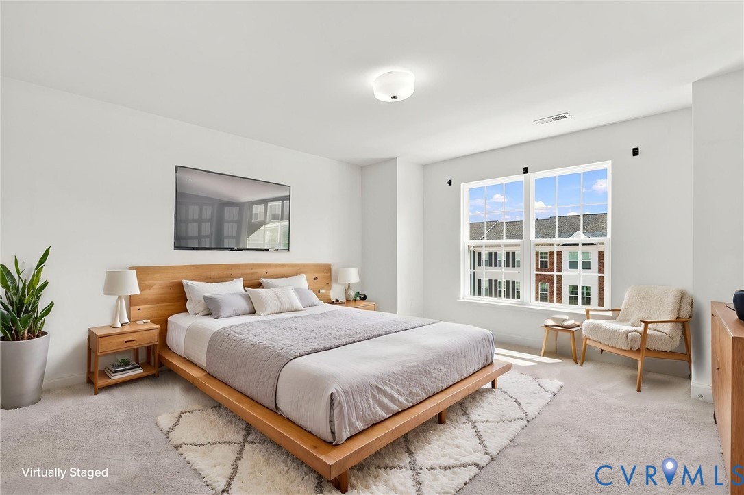 Carpeted bedroom with a large window and ceiling-mounted light fixture