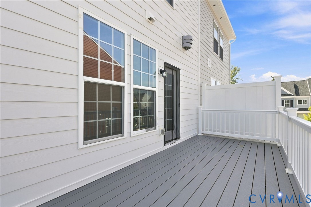 Spacious exterior deck with gray composite decking and white vinyl railings