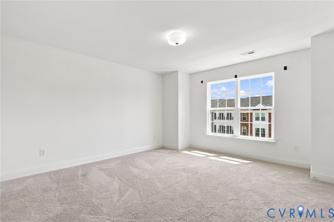 Carpeted flooring, white walls, white trim, recessed lighting, and a large multi-pane window