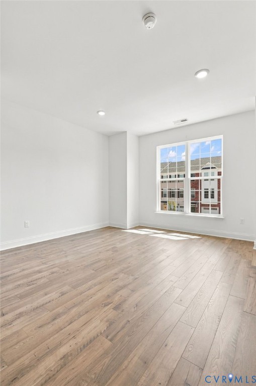 Recessed lighting, wood-finish flooring, and white painted walls