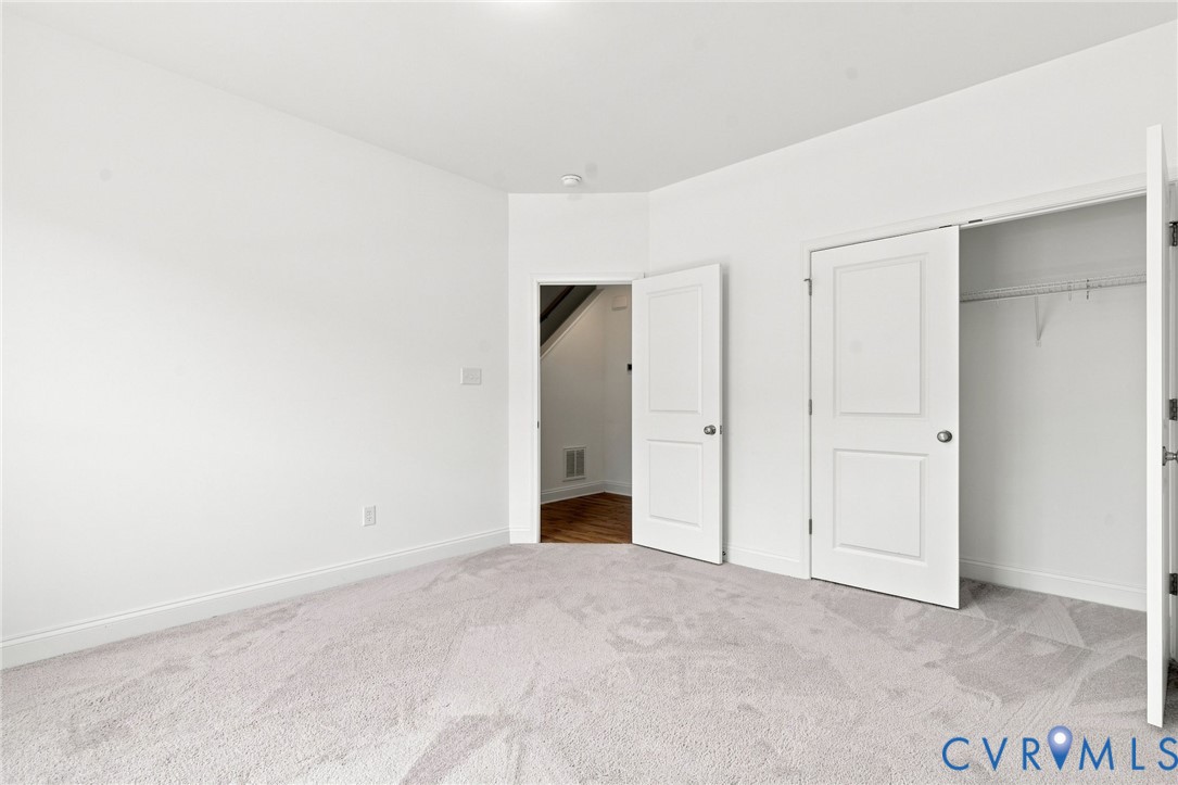 Plush carpet flooring, white painted walls, recessed ceiling lighting, and a closet with bifold doors