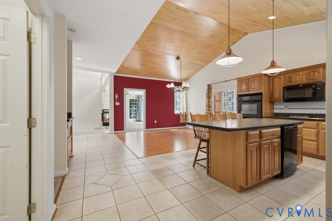 Spacious kitchen featuring wood cabinetry, stainless steel appliances, and a substantial island with seating