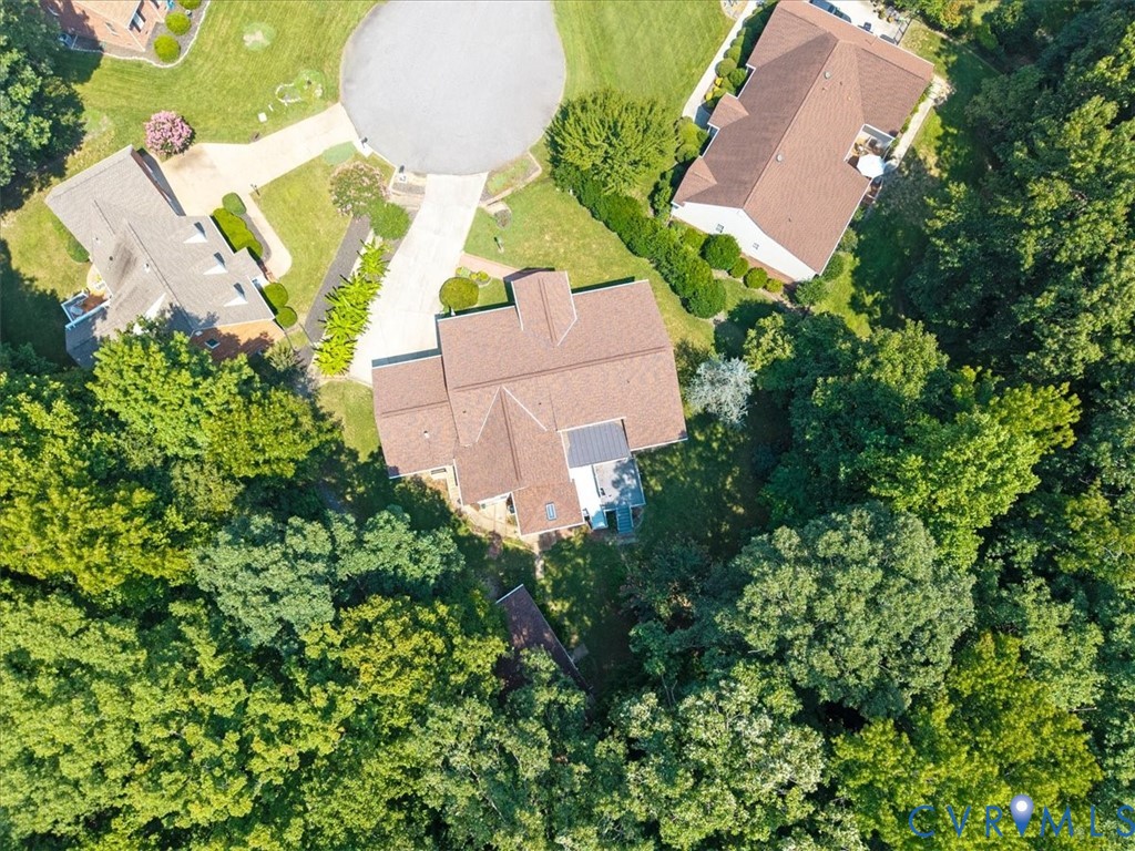 Aerial view showcasing a substantial estate nestled on lush, mature landscaping with towering trees