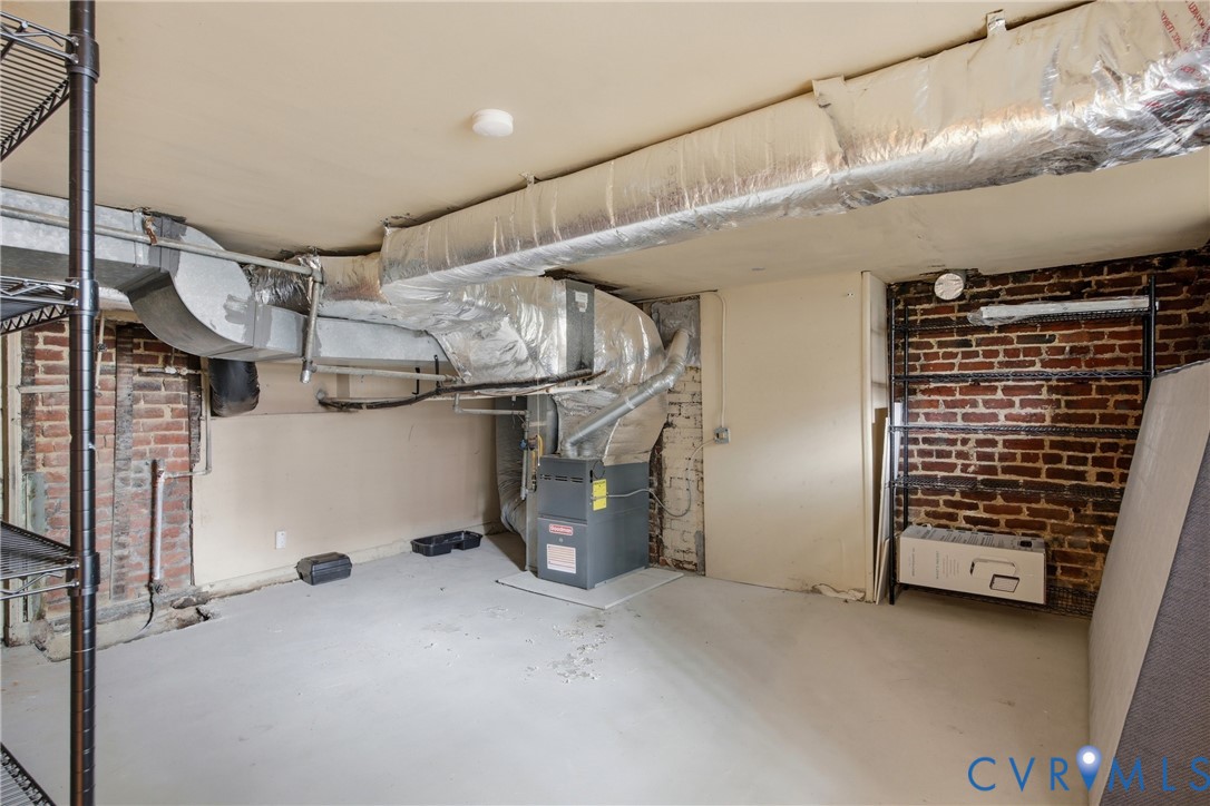 Exposed brick wall accents, utility access, and ample storage shelving