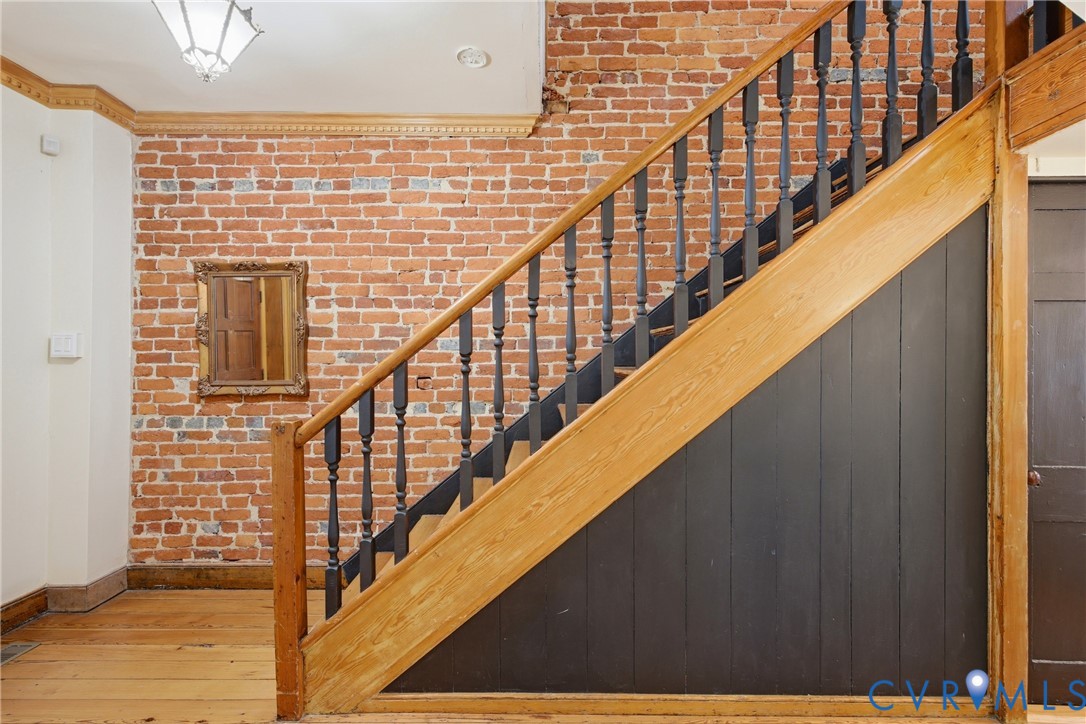 Exposed brick wall, natural wood staircase, wood flooring