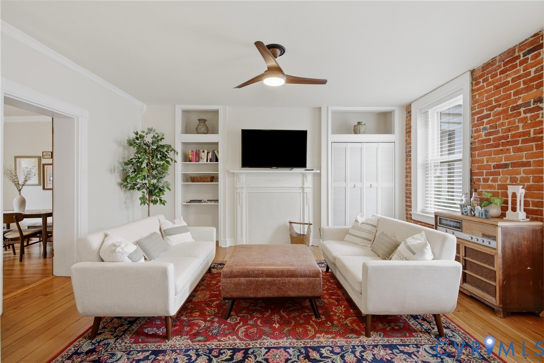 Hardwood floors, exposed brick accent wall, built-in shelving, natural light, ceiling fan Hardwood floors, exposed brick accent wall, built-in shelving, natural light, ceiling fan