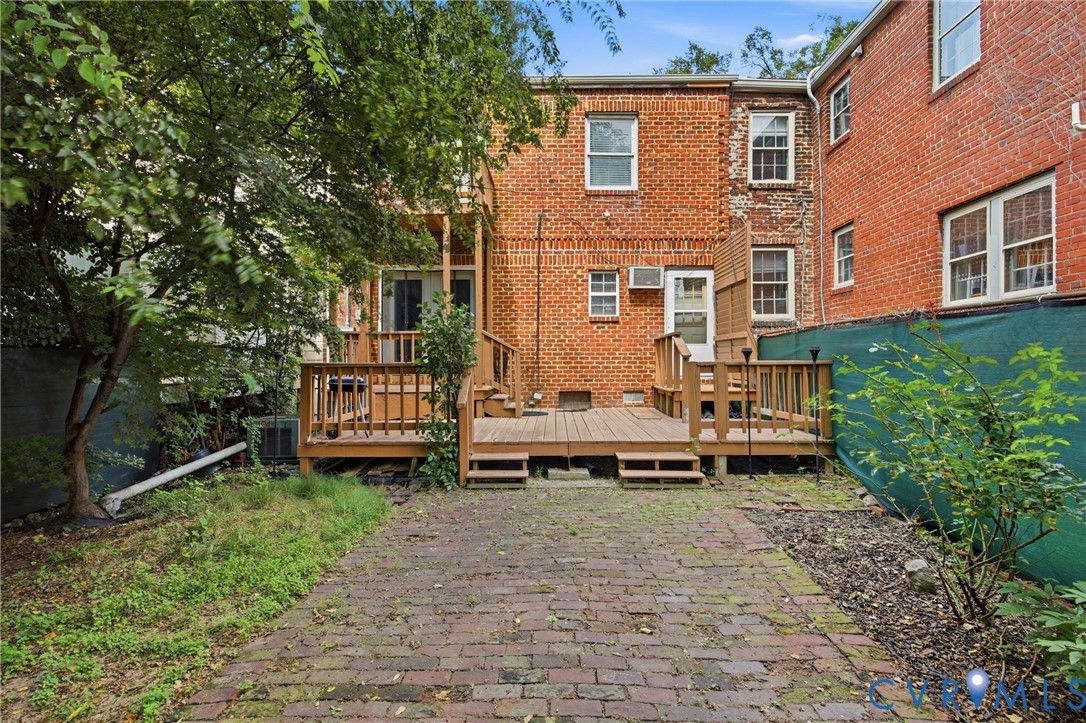 Brick exterior with a multi-level wood deck, wood railings, fenced