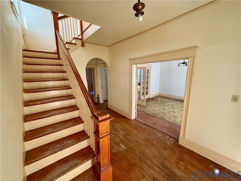 Hardwood flooring, painted balusters, wood handrail, and arched doorways Hardwood flooring, painted balusters, wood handrail, and arched doorways