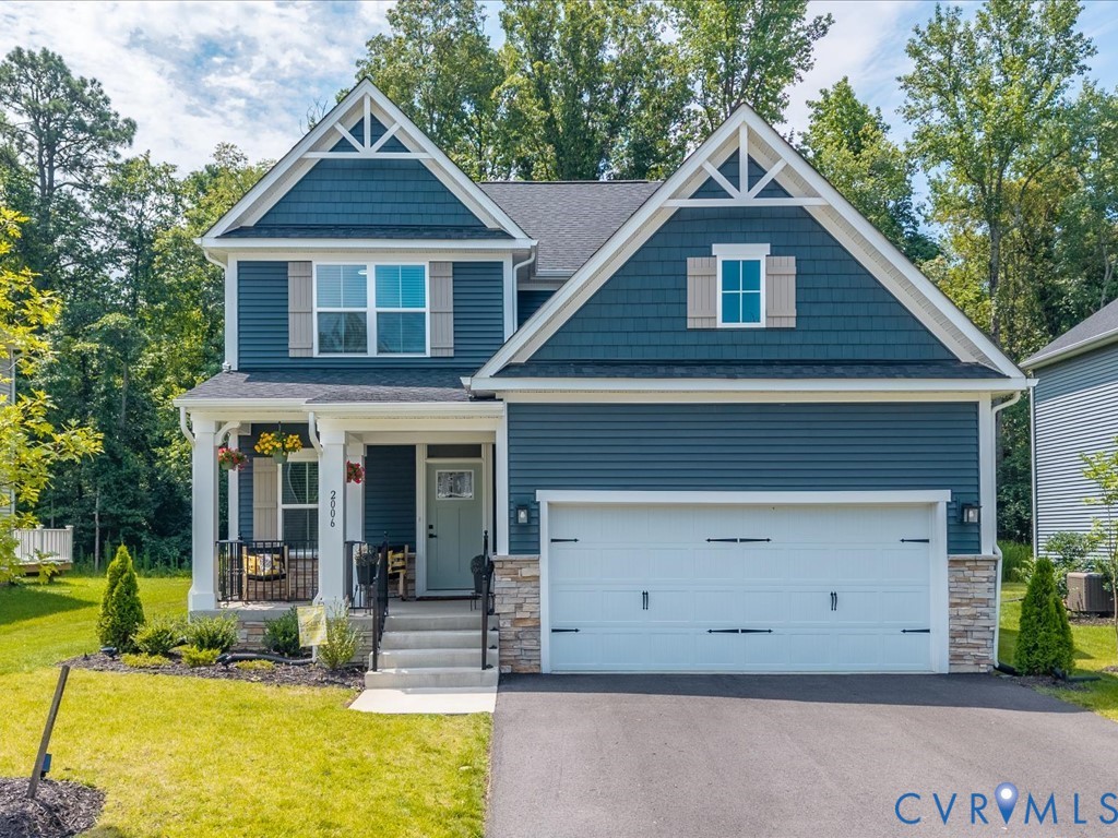 Two-story residence featuring blue siding, white trim, and a prominent front-facing garage