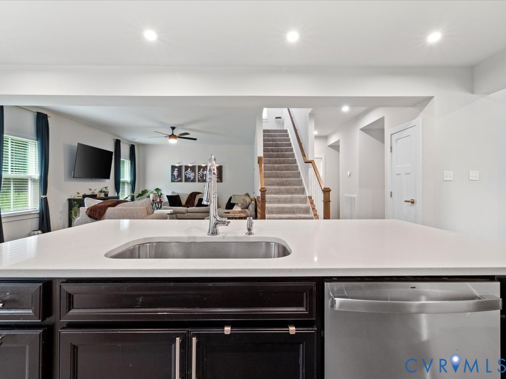 Kitchen island with a stainless steel undermount sink, gooseneck faucet, and integrated dishwasher