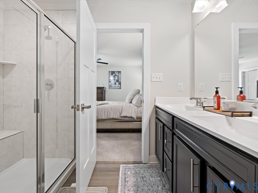 Dual vanity with white countertops, dark wood-finish cabinetry, and brushed nickel hardware