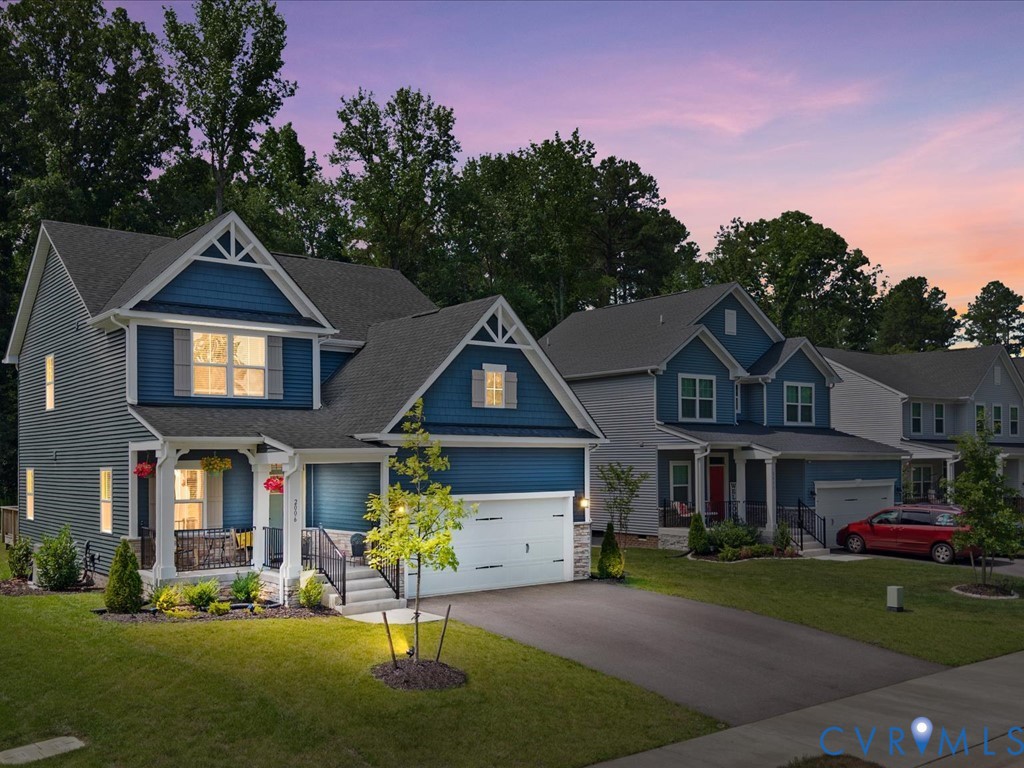 Two-story residence featuring blue siding, a covered front porch, and a two-car garage