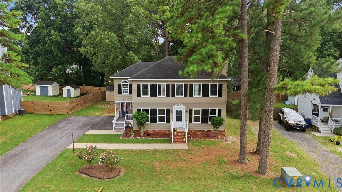 Two-story exterior with a covered entry, white porch railings, and black window shutters Two-story exterior with a covered entry, white porch railings, and black window shutters