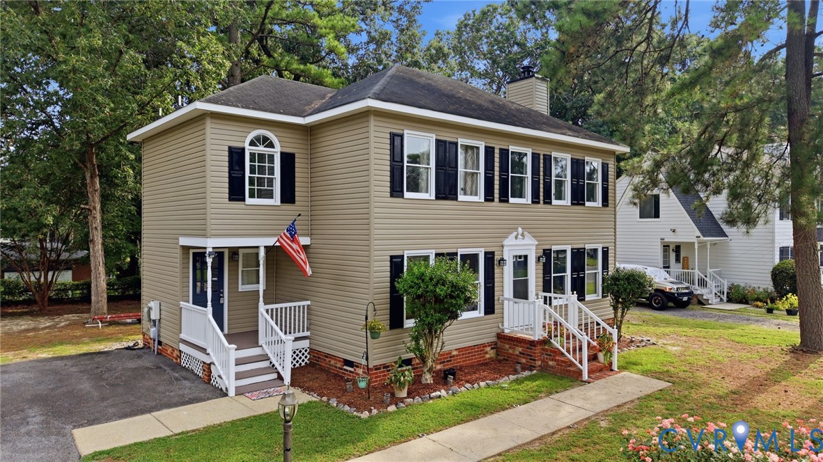 Two-story residence featuring light-toned siding and dark shutters Two-story residence featuring light-toned siding and dark shutters