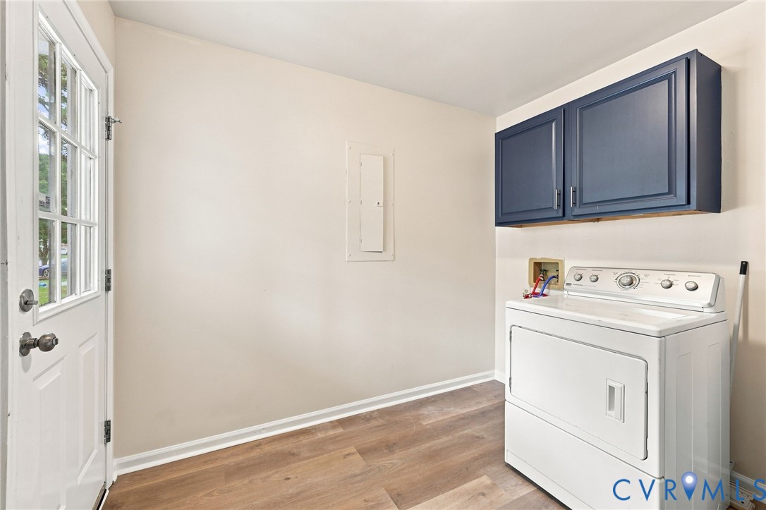 Wood-finish flooring, white walls, and a white paneled door with windowpanes