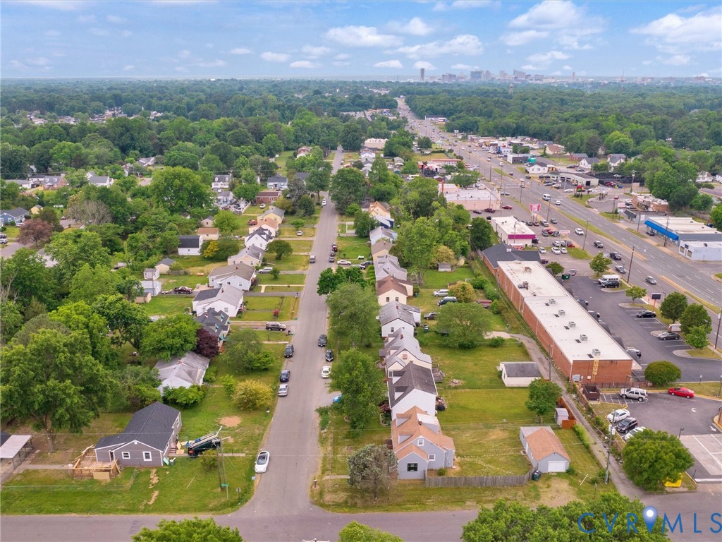 Residential street lined with single-story homes, established trees, and green lawns