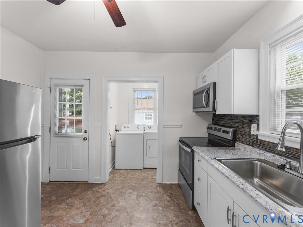 Kitchen featuring white cabinetry, a stainless steel sink, a dark tiled backsplash, and light speckled countertops