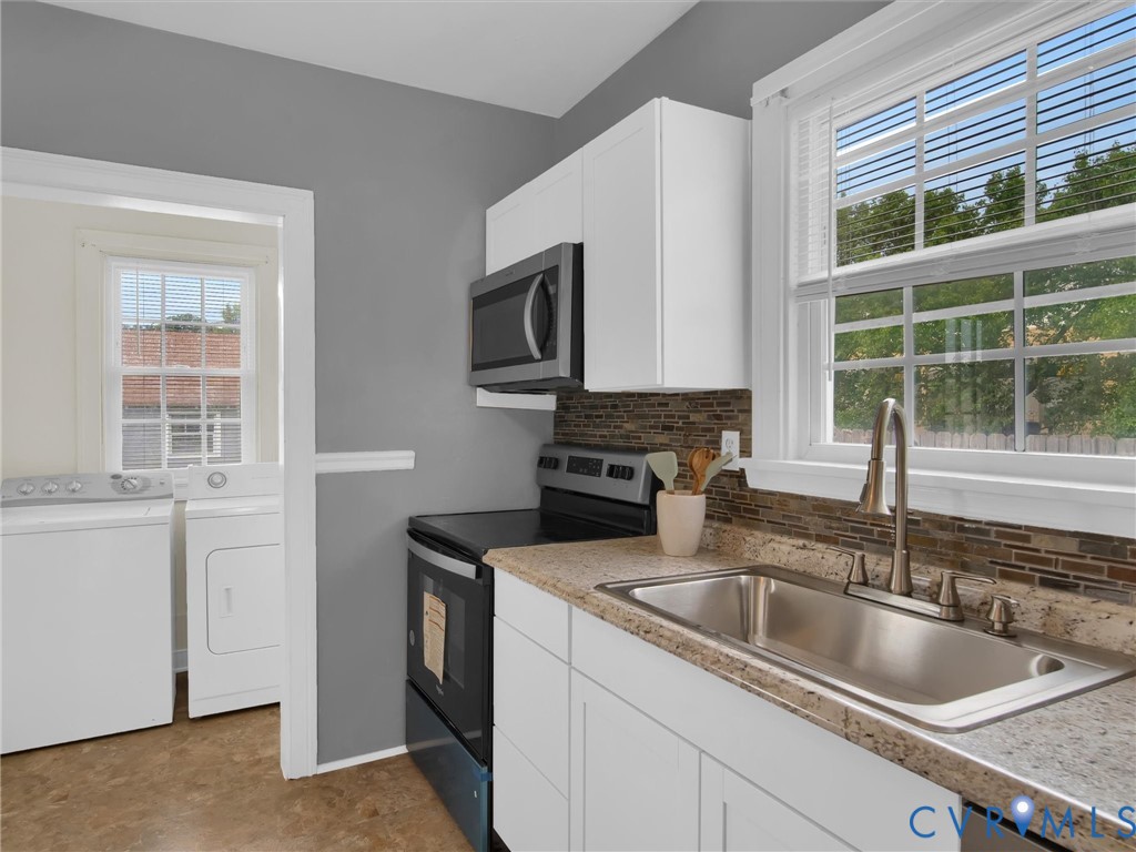 Kitchen featuring white cabinetry, a stainless steel sink with a gooseneck faucet, light-colored countertops, and a mosaic tile backsplash