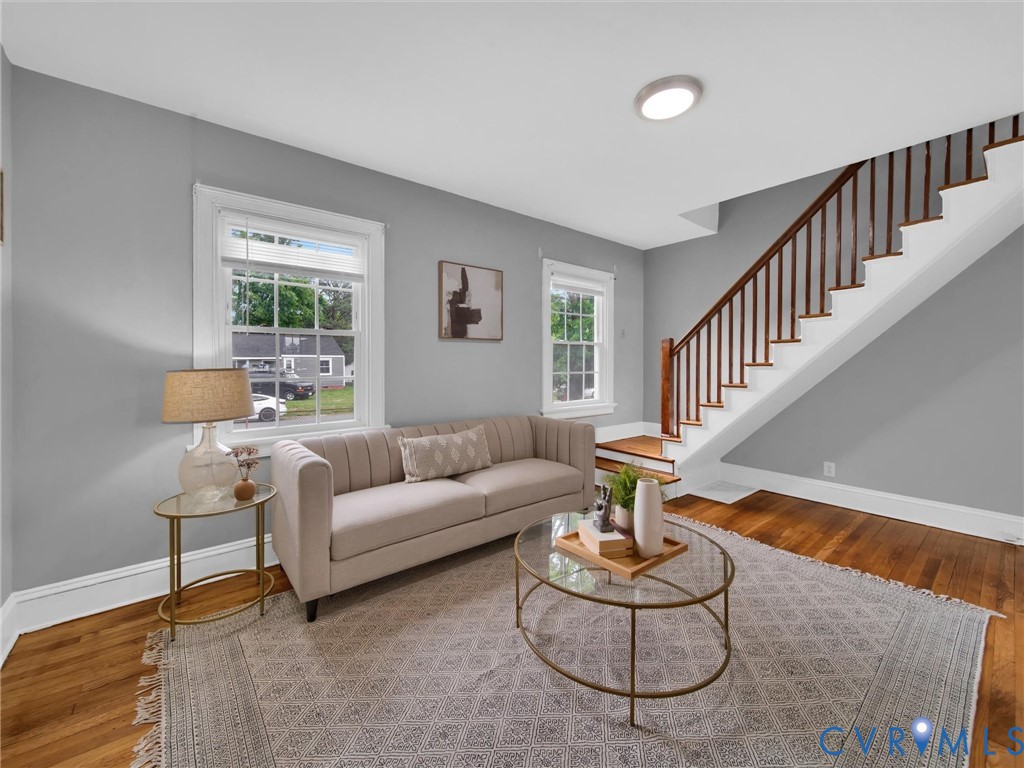 Living area featuring wood-finish flooring, light grey walls, and white trim