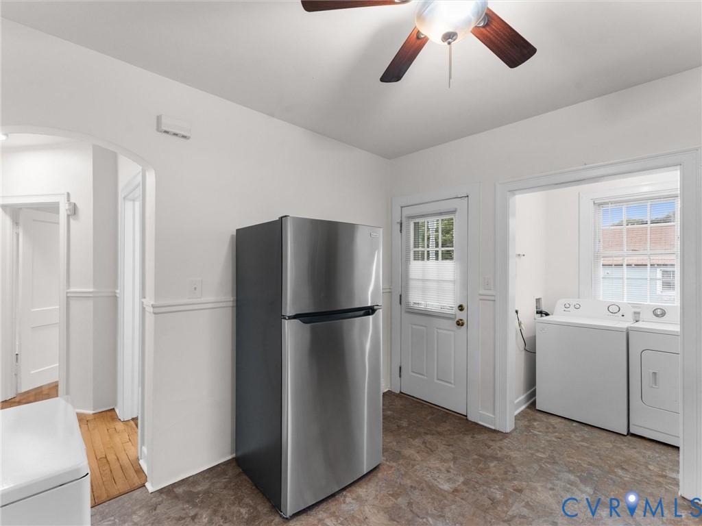 Functional utility space featuring a stainless steel refrigerator, ceiling fan, and vinyl flooring