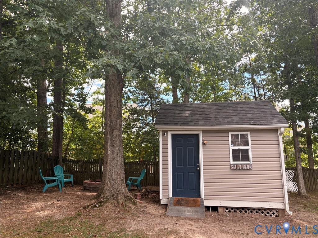 Detached storage structure with siding exterior, single window, and dark entry door Detached storage structure with siding exterior, single window, and dark entry door