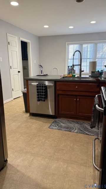 Kitchen island with dark cabinetry, stainless steel dishwasher, and a contemporary black faucet Kitchen island with dark cabinetry, stainless steel dishwasher, and a contemporary black faucet