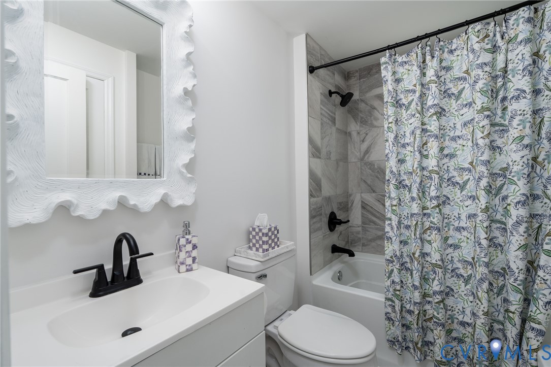 White vanity with integrated sink, black-finish faucet, and coordinating mirror