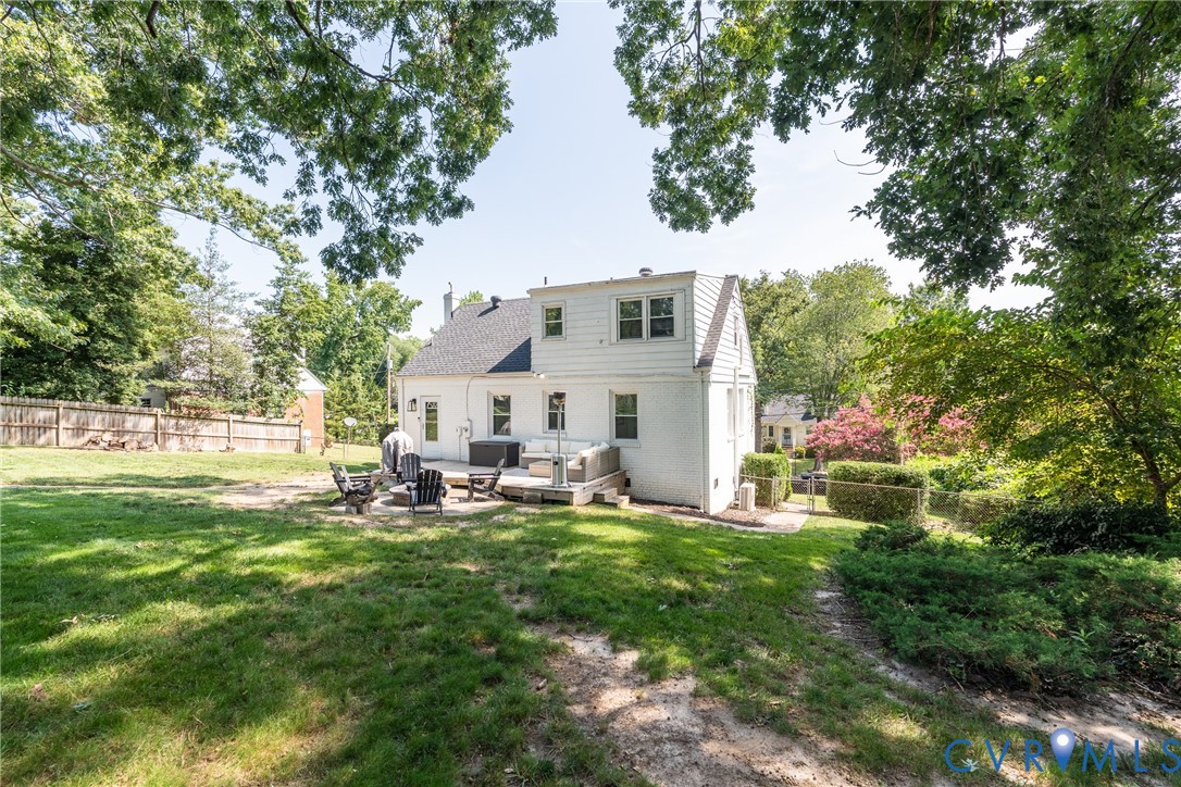 Expansive backyard with a manicured lawn, dedicated patio space, and mature trees