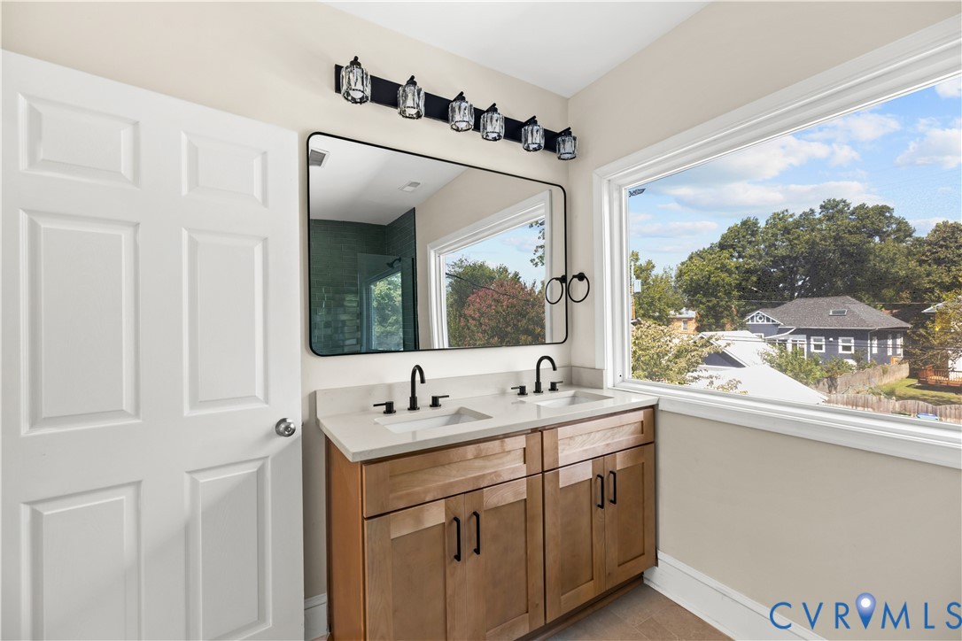 Dual vanity with stone-finish countertop, two undermount sinks, and matte black fixtures