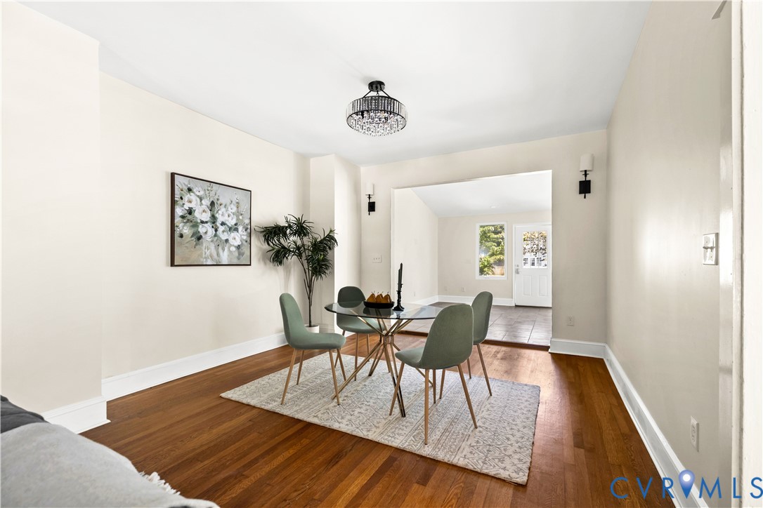 Hardwood flooring throughout, recessed archway, modern chandelier, wall sconces, and neutral wall tones Hardwood flooring throughout, recessed archway, modern chandelier, wall sconces, and neutral wall tones
