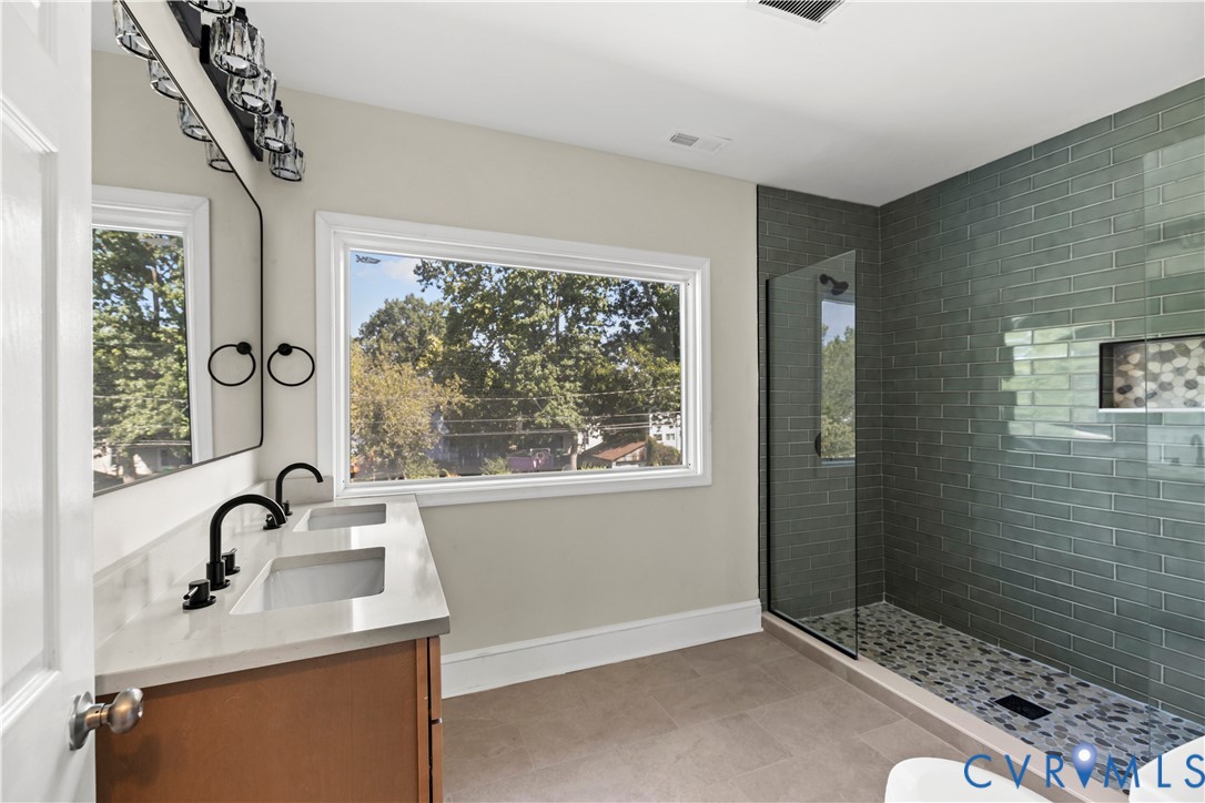 Dual vanity with integrated sinks, matte black fixtures, and a modern light fixture